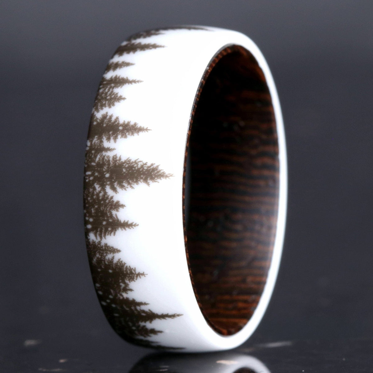 Men's white ceramic wedding band with a forest tree-line design and dark wood interior