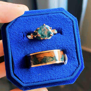 Matching rose gold moss agate couples ring set in a blue velvet ring box, his 8mm band inlaid with koa wood