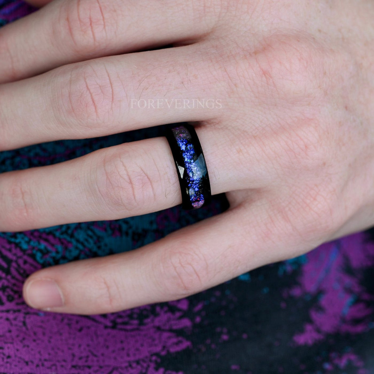 Orion Nebula black tungsten ring worn on hand over purple fabric