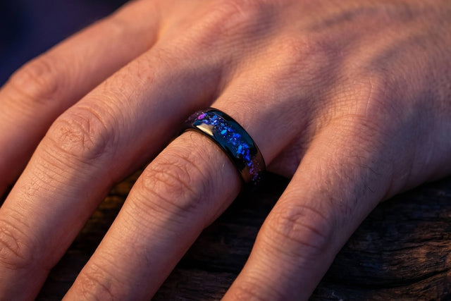 Orion Nebula ring: black tungsten band with blue and purple nebula inlay worn on a man's left hand
