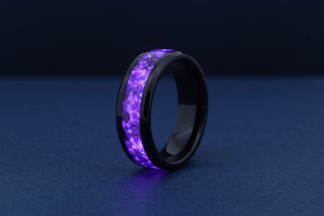 Black tungsten band with purple glow-in-the-dark inlay, lit up in the dark