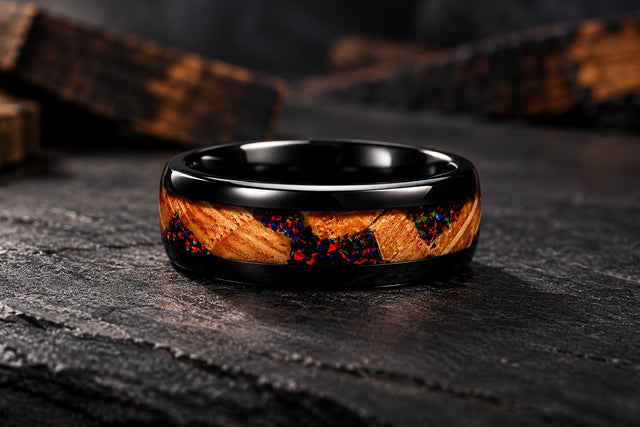 Black tungsten band with whiskey barrel oak and black fire opal inlay on dark slate