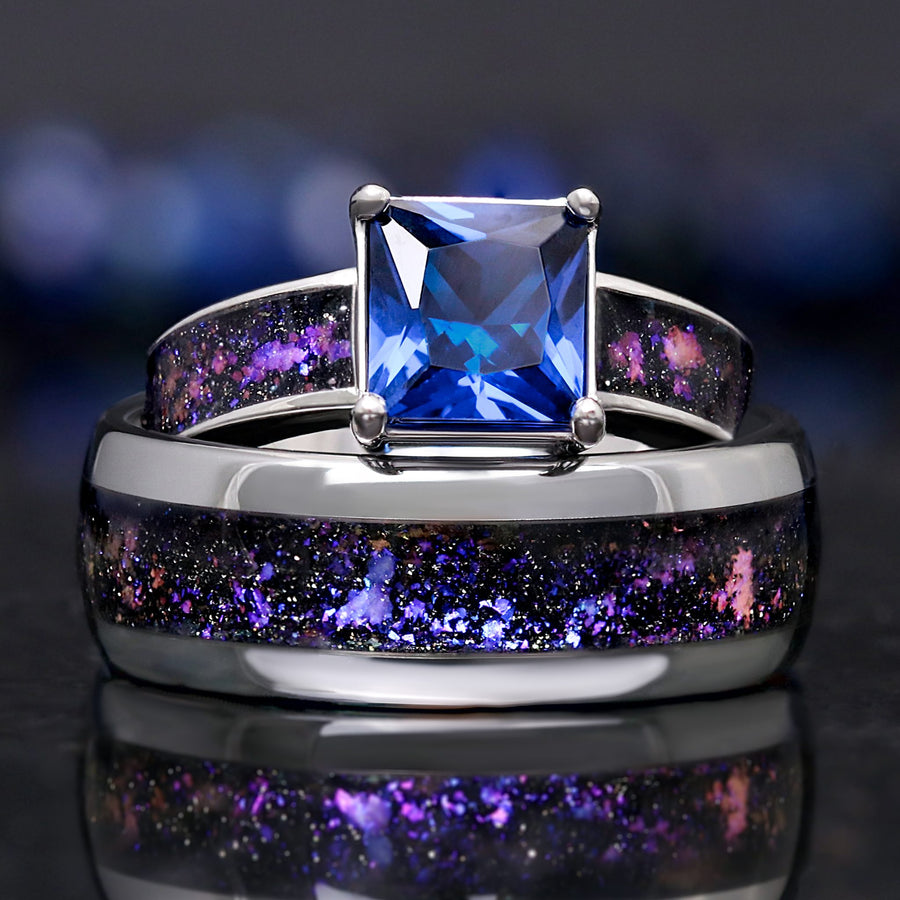 His and hers engagement rings in silver with Orion nebula inlays, her sapphire ring behind his band