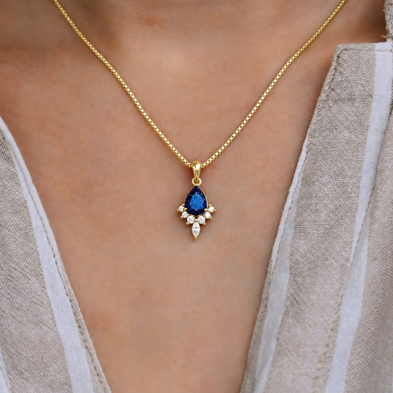 Pear blue sandstone pendant necklace on a gold box chain, worn at the neck