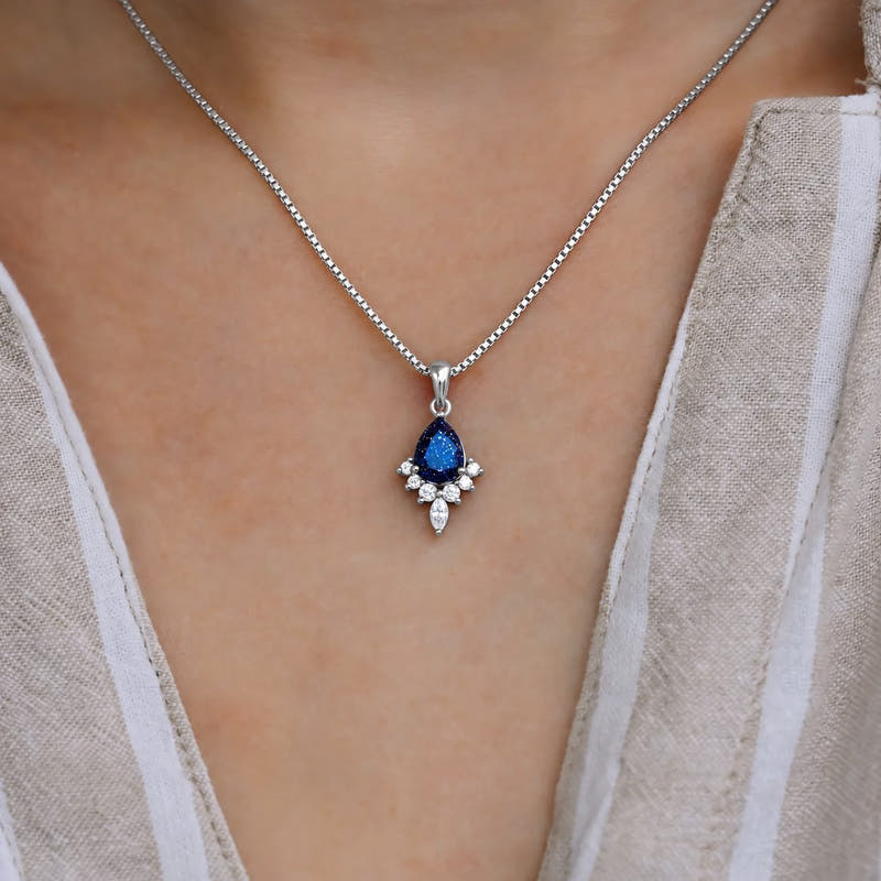 Pear blue sandstone pendant necklace on a silver box chain, worn at the neck