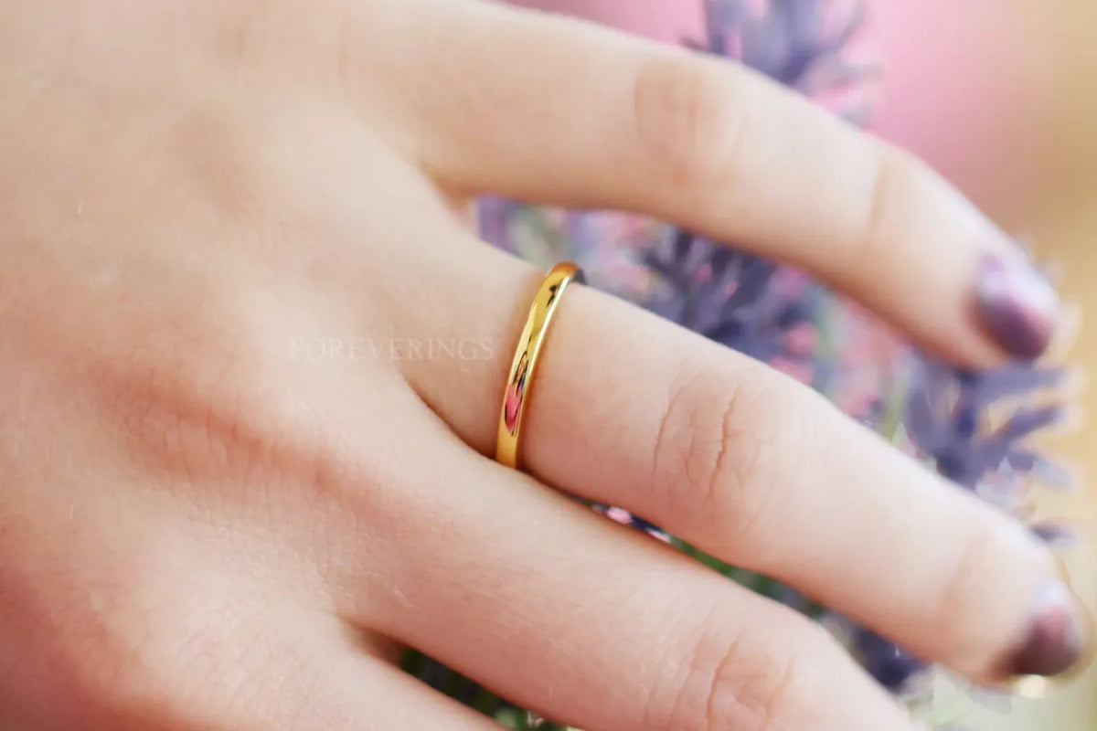 Thin gold classic wedding band worn on her hand